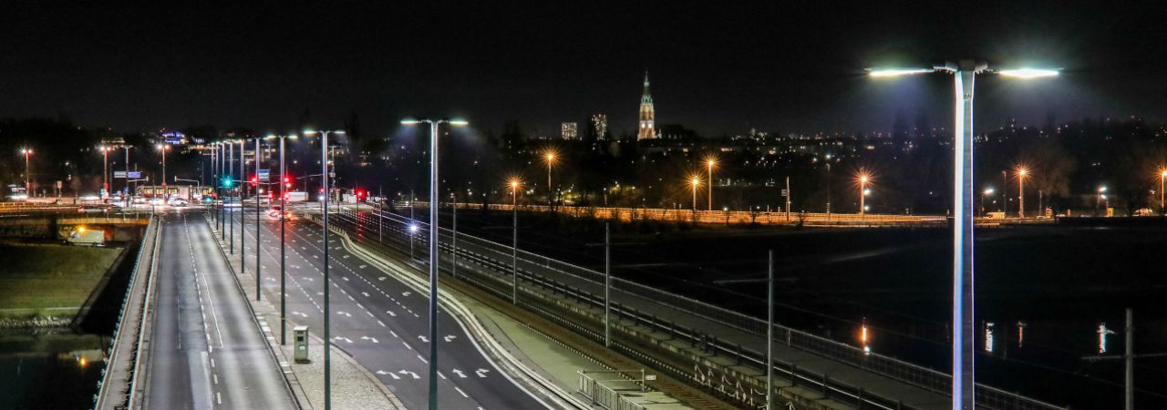 Beleuchtete breite Straße in Wien, im Hintergrund die Stadtsilhouette